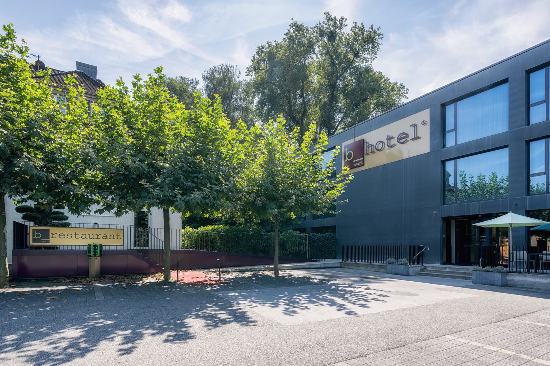 Exterior view of the bsmart Hotel Widnau with adjacent restaurant in sunny weather