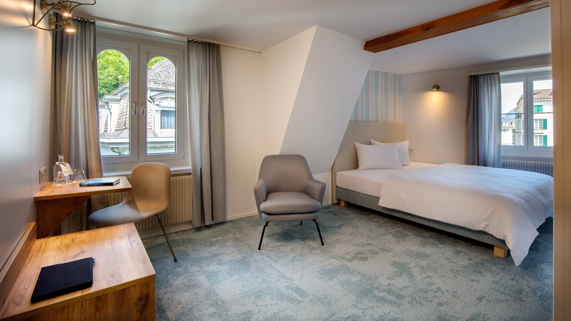 Modernly furnished hotel room at Hotel Krone by B Smart Superior with double bed, seating area, and desk.