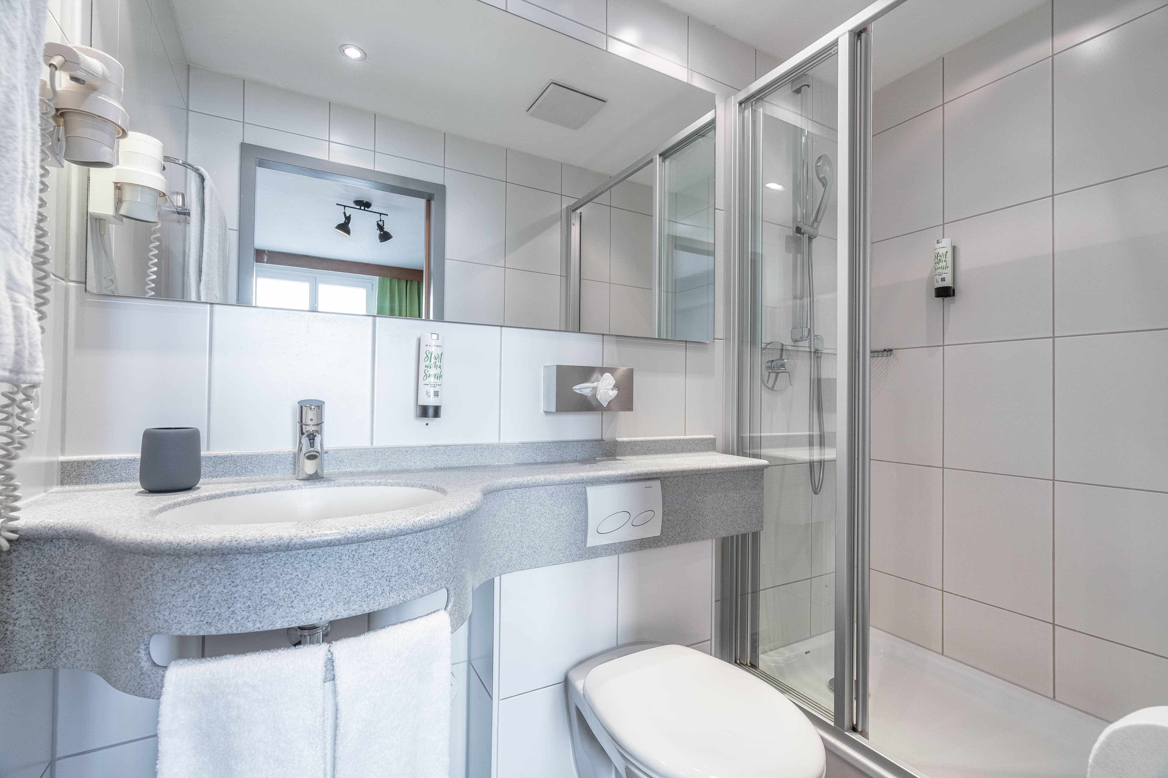 Modern bathroom in Flex Motel Schonenwerd with shower, toilet, and mirror.