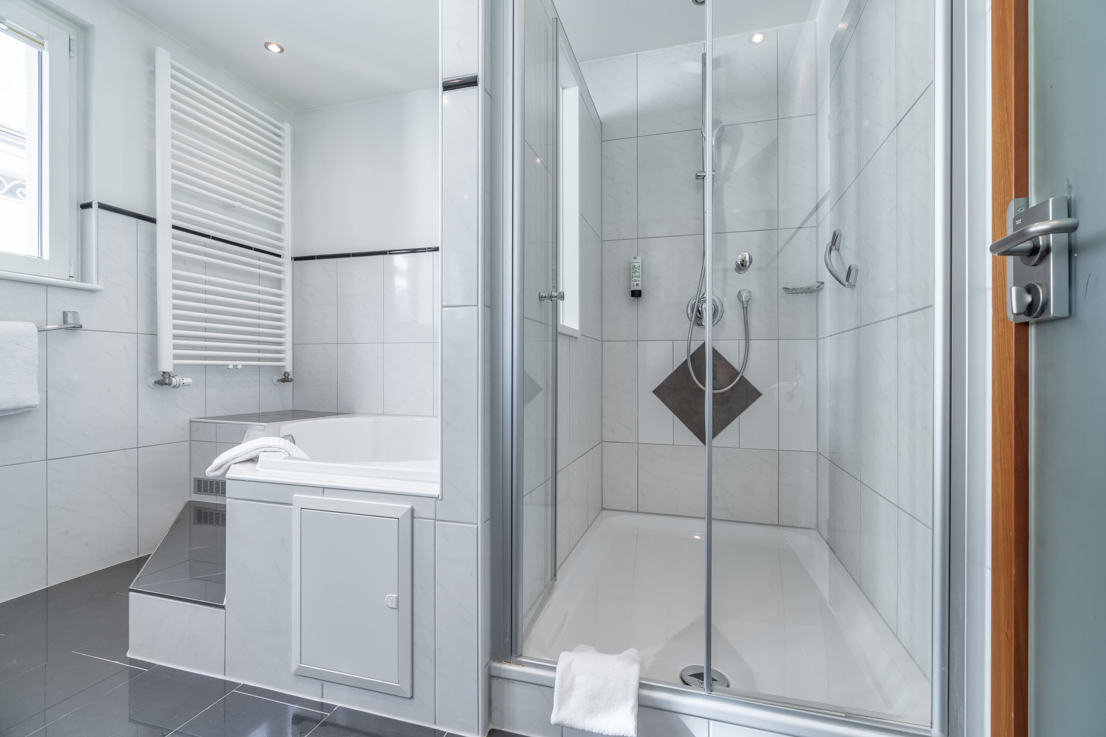 Bathroom of a Junior Suite in Flex Motel Schonenwerd with shower and bathtub.