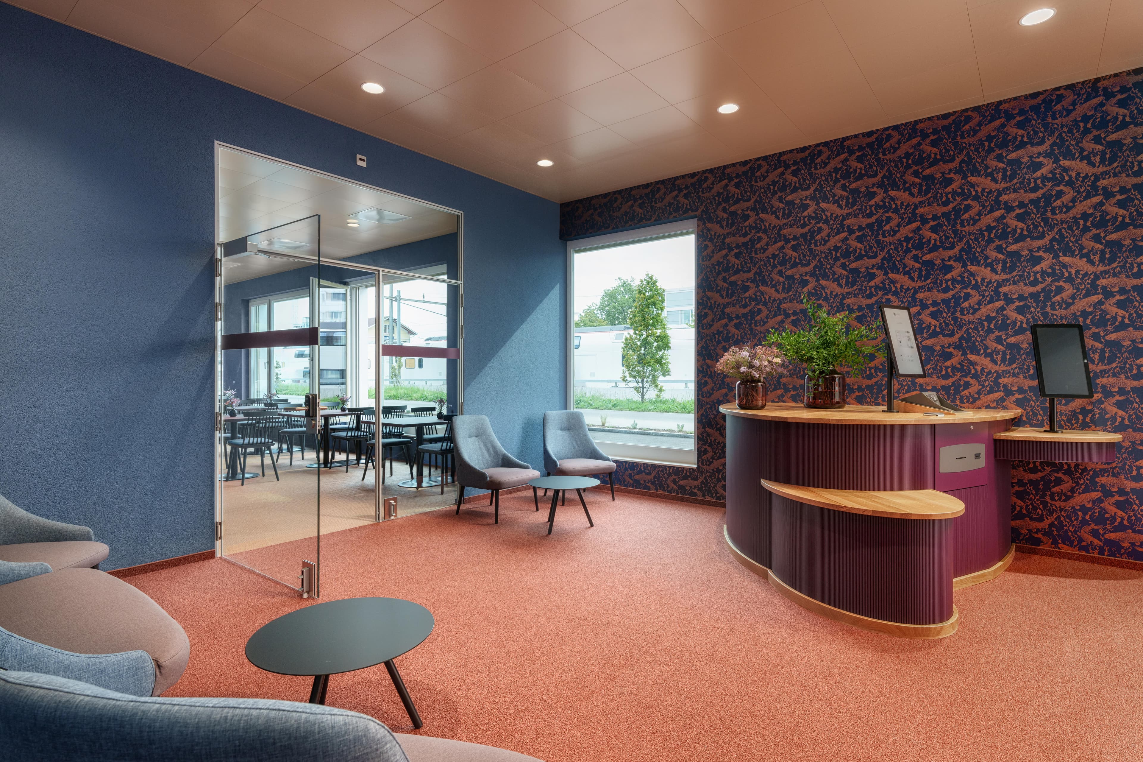 Modern reception in the B smart Hotel Arbon with self check in area and stylish waiting zone.